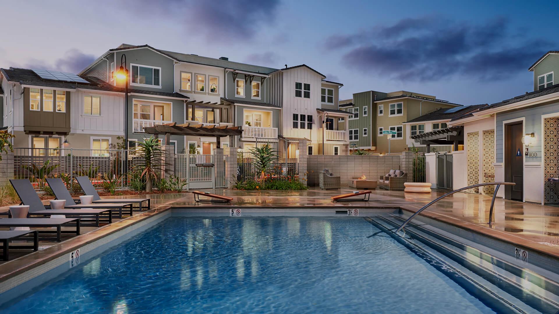 The exterior of a new Condo community with a pool.